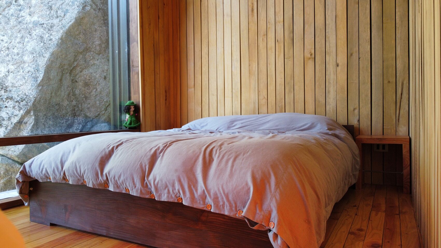 Dormitório com cama de casal e janela com vista para o lago